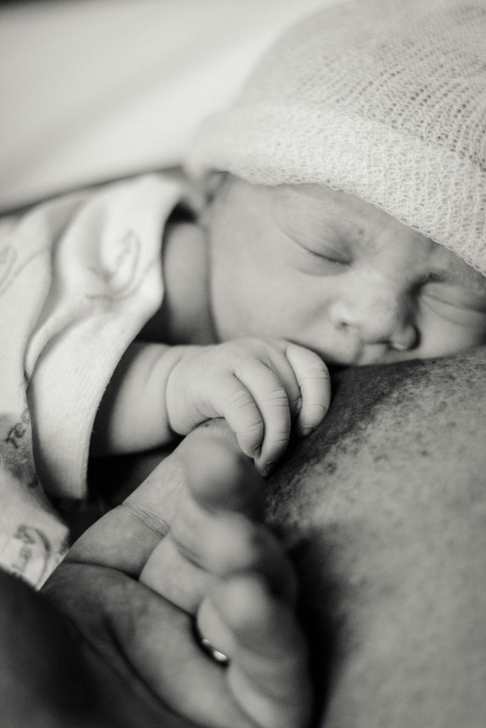 Newborn baby sleeping on parent’s chest, illustrating skin-to-skin contact and bonding after bringing baby home