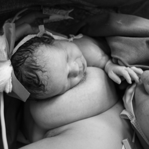 mom with newborn laying on breast