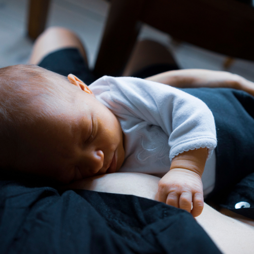 baby laying on mom's breast